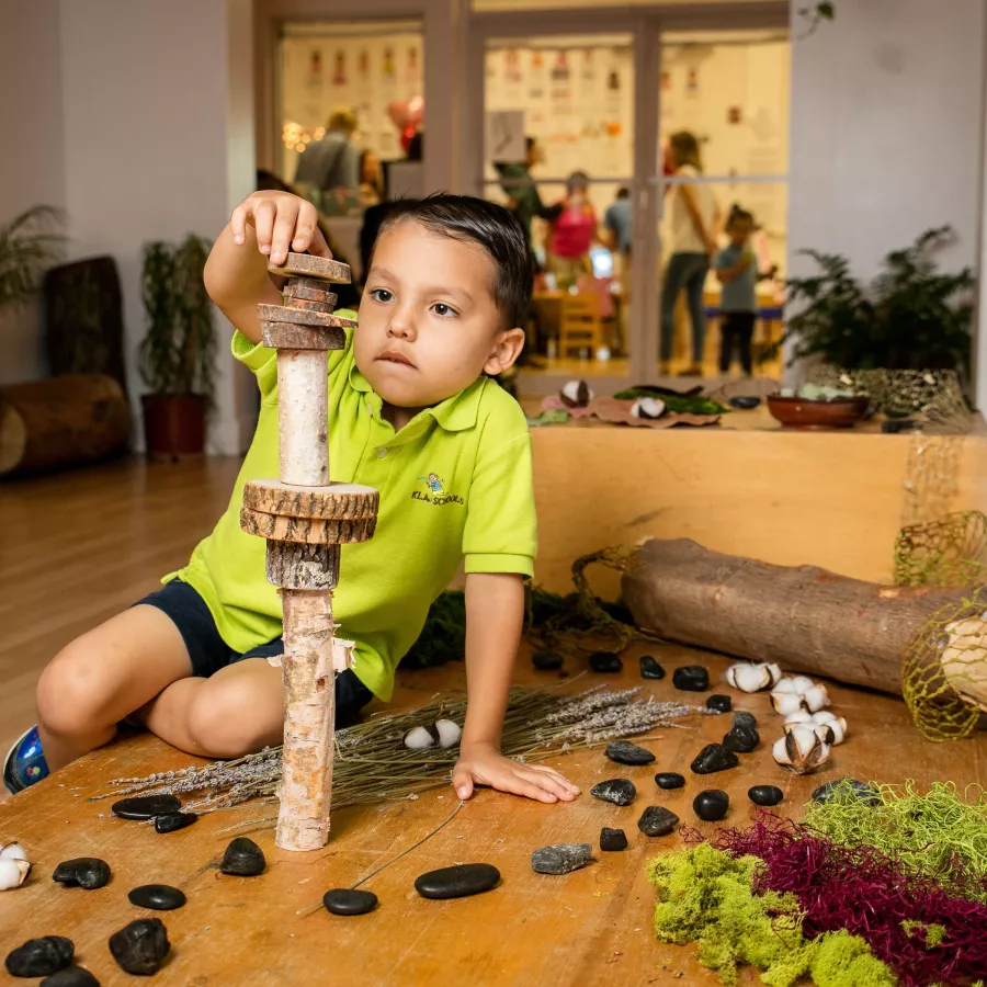 a student at our preschool stacking wooden pieces
