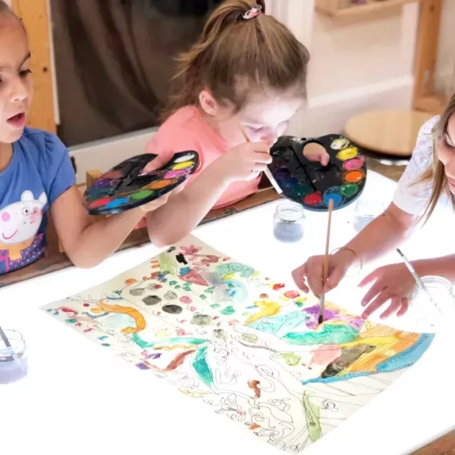three students coloring in our after school care