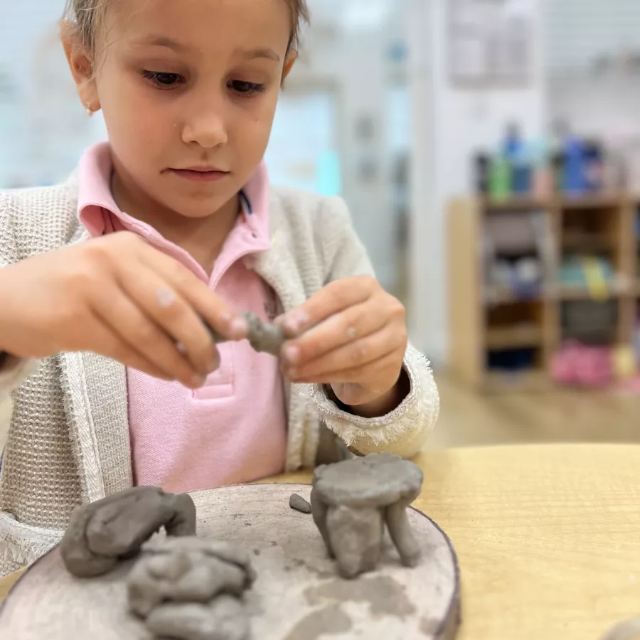 girl building sculptures out of clay at our Doral daycare