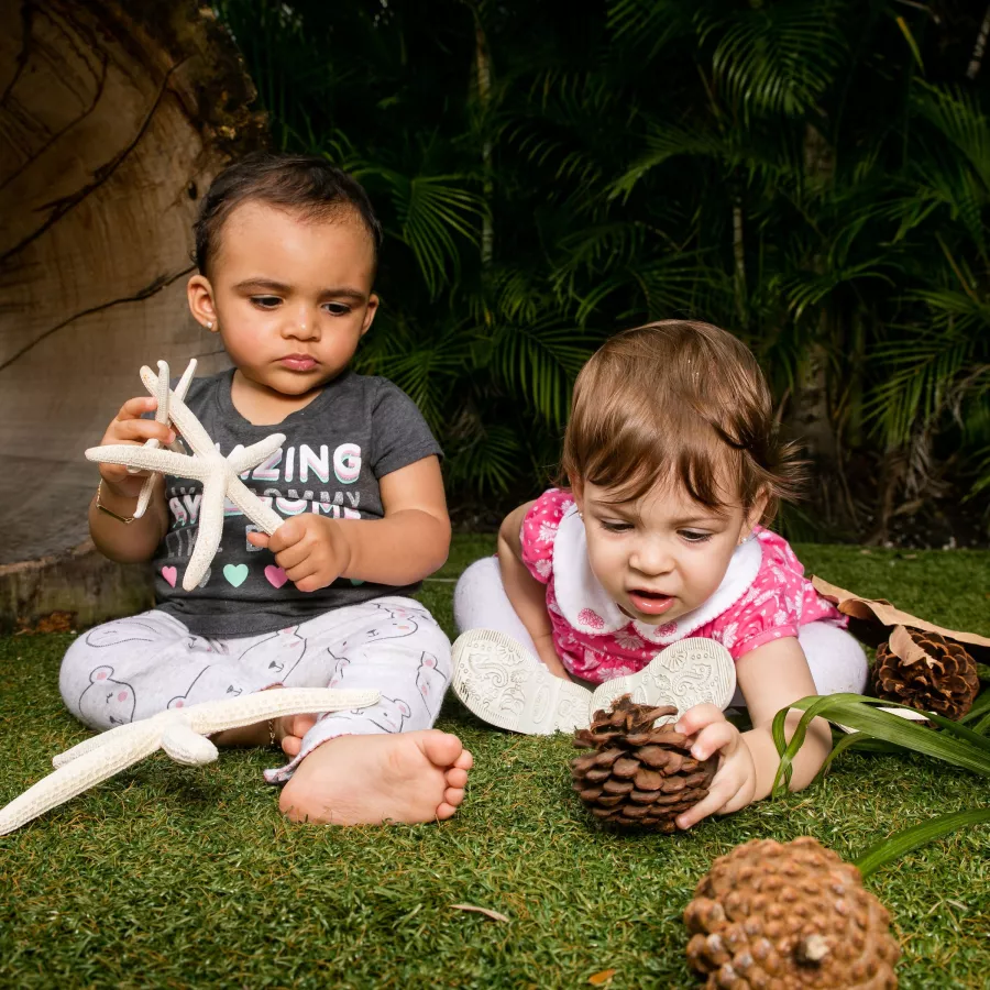 2 babies playing with pinecones and starfish at our nursery for infants