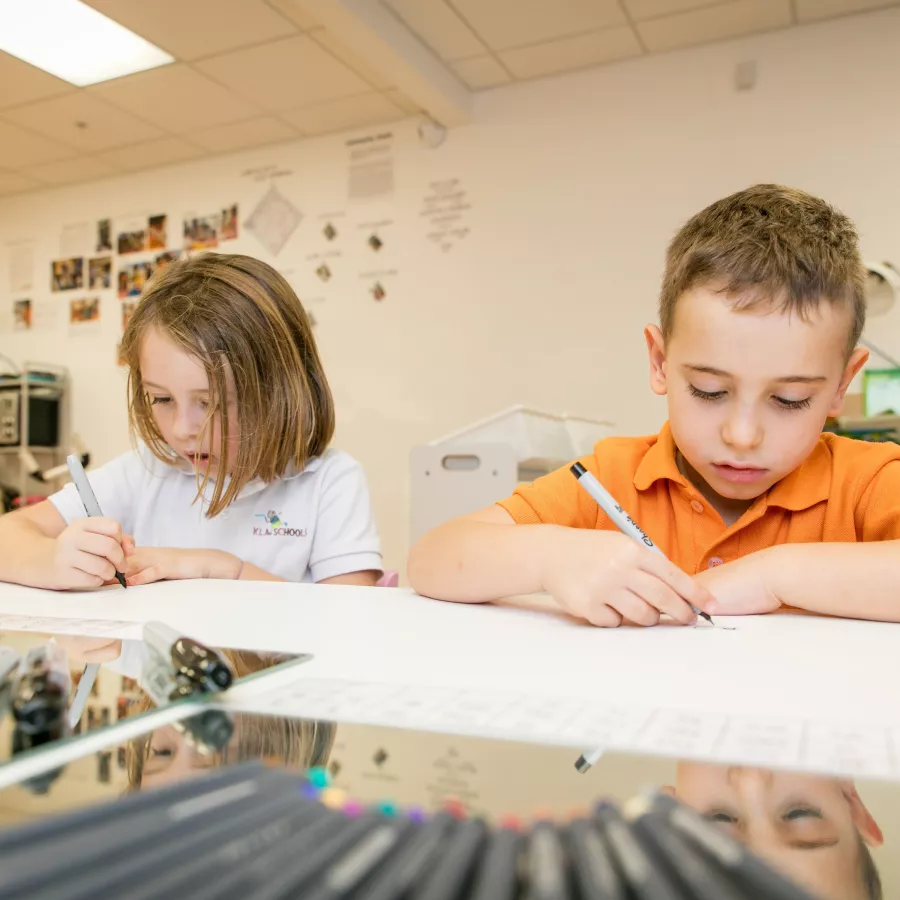 two preschool students drawing in our before and after school program