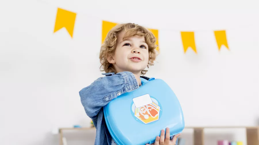 Front view happy boy holding kit