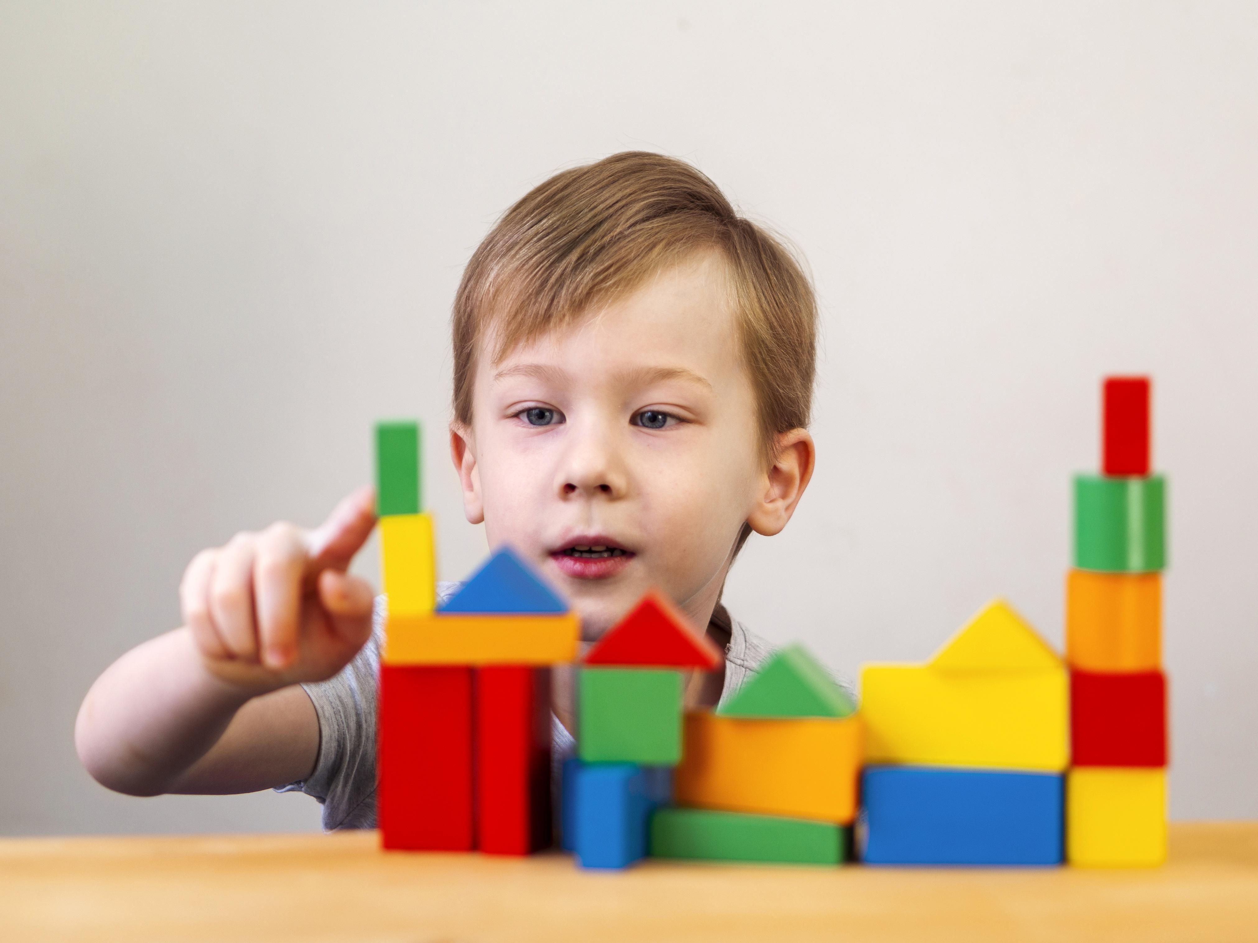 Kid playing with different colorful shapes