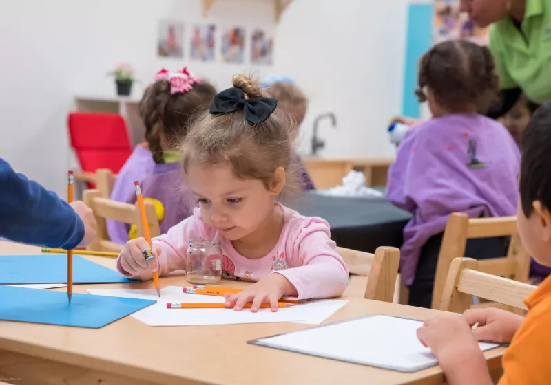 Preschool child learning to use pencil to write