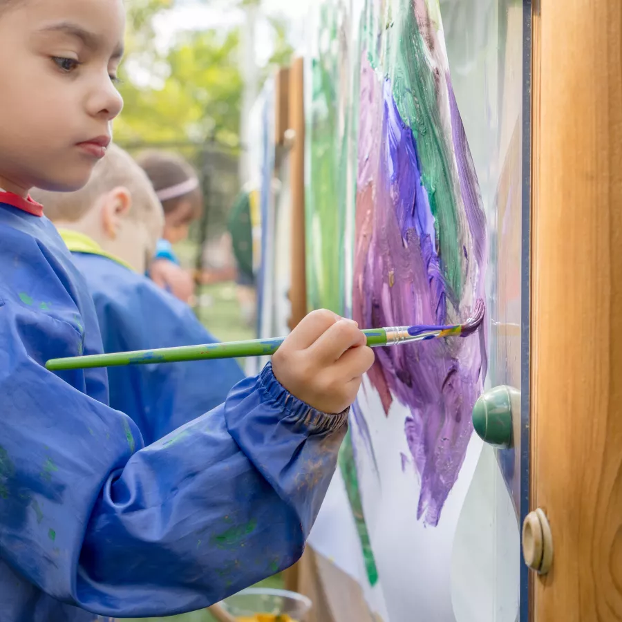 Preschooler painting outside
