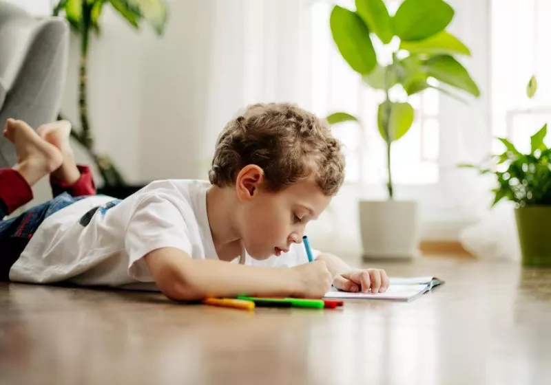 Little boy draws lying floor having fun happy childhood positive emotions side view 1048944 18708719
