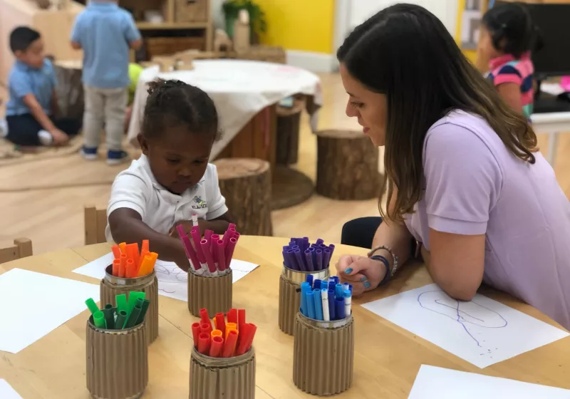 Teacher with girl in classroom