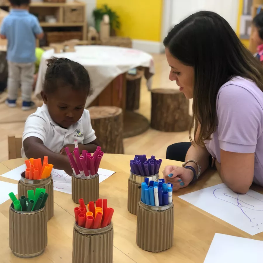 Teacher with girl in classroom