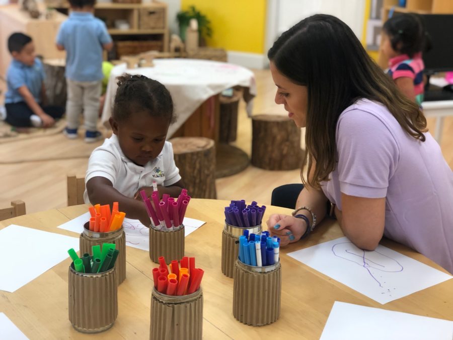 Teacher with girl in classroom