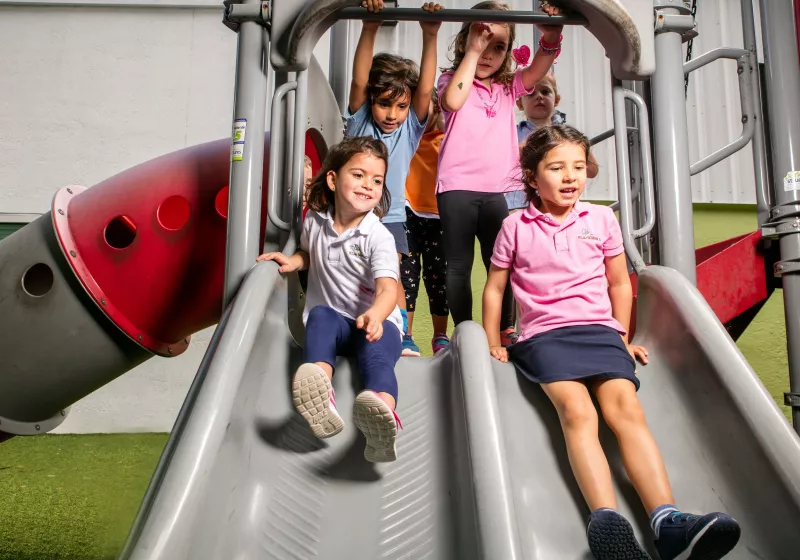 a group of students playing on a slide at our summer camp for kids
