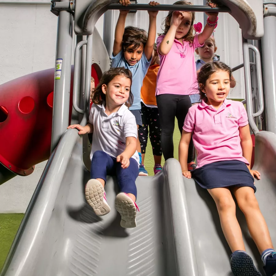a group of students playing on a slide at our summer camp for kids